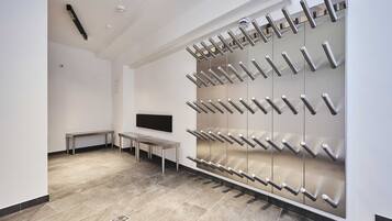 A modern bathroom with a large mirror, a bench, and a wall-mounted towel rack.