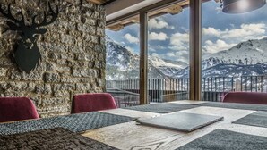 A dining area with a stone wall, a mounted deer head, and a table with placemats. - Vacation apartment Melisande 3 - The Peak Sölden (Sölden)