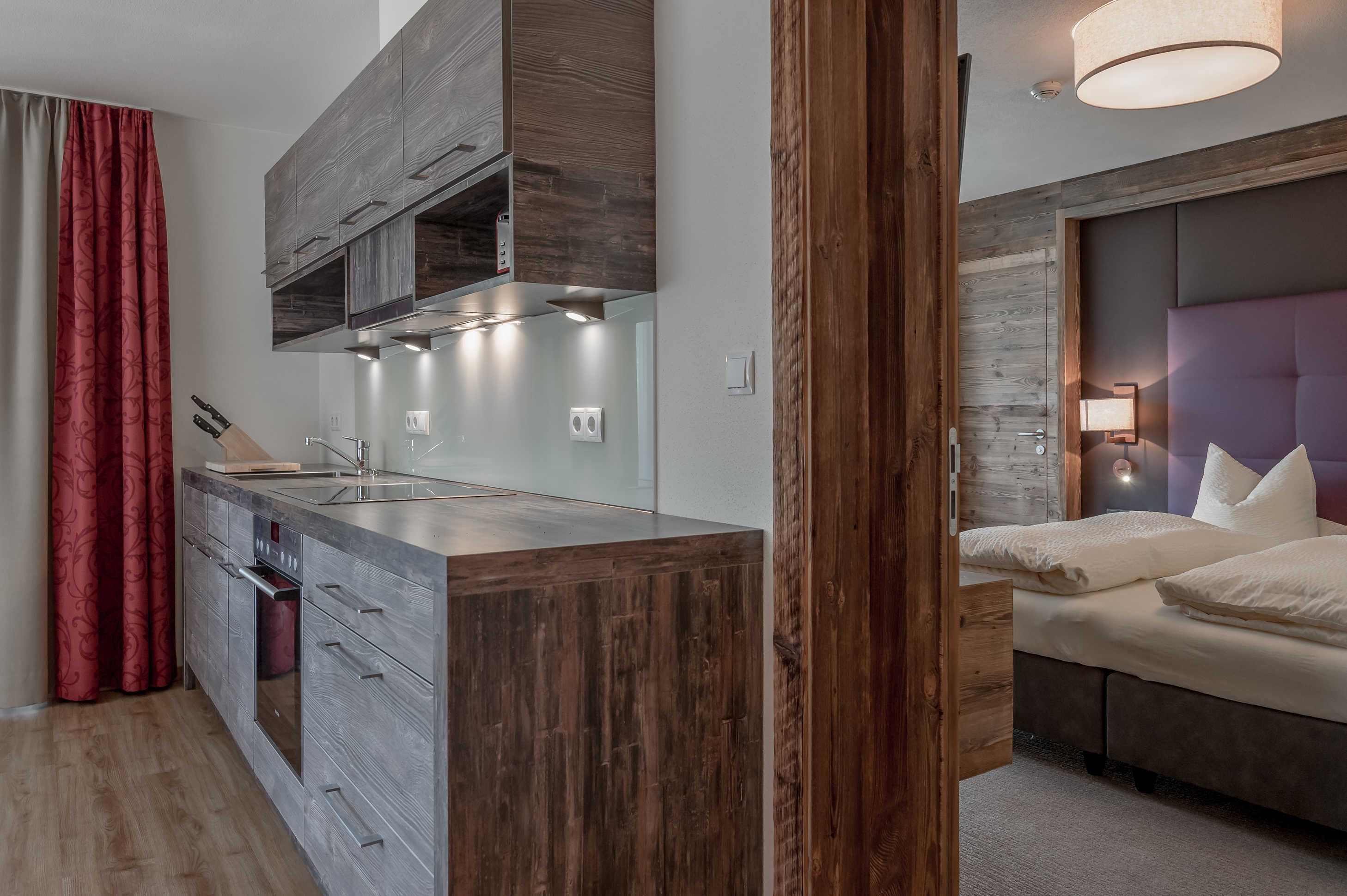 A modern kitchen with wooden cabinets, a built-in oven, and a central island.