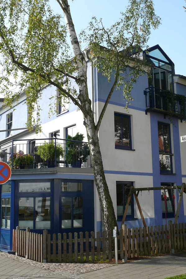 A two-story building with a balcony and a wooden fence.