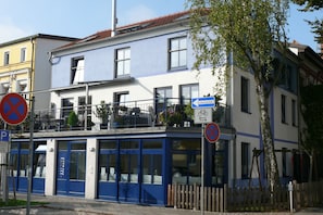 A building with a blue facade, multiple windows, and balconies.