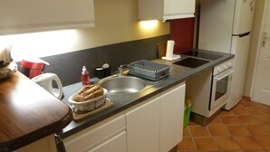 A compact kitchen with a sink, stove, and microwave. - Studio in Didier FORT DE FRANCE (Fort de France)