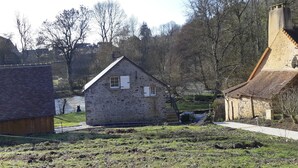 Una casa de piedra con techo inclinado, un pequeño porche y una ventana.