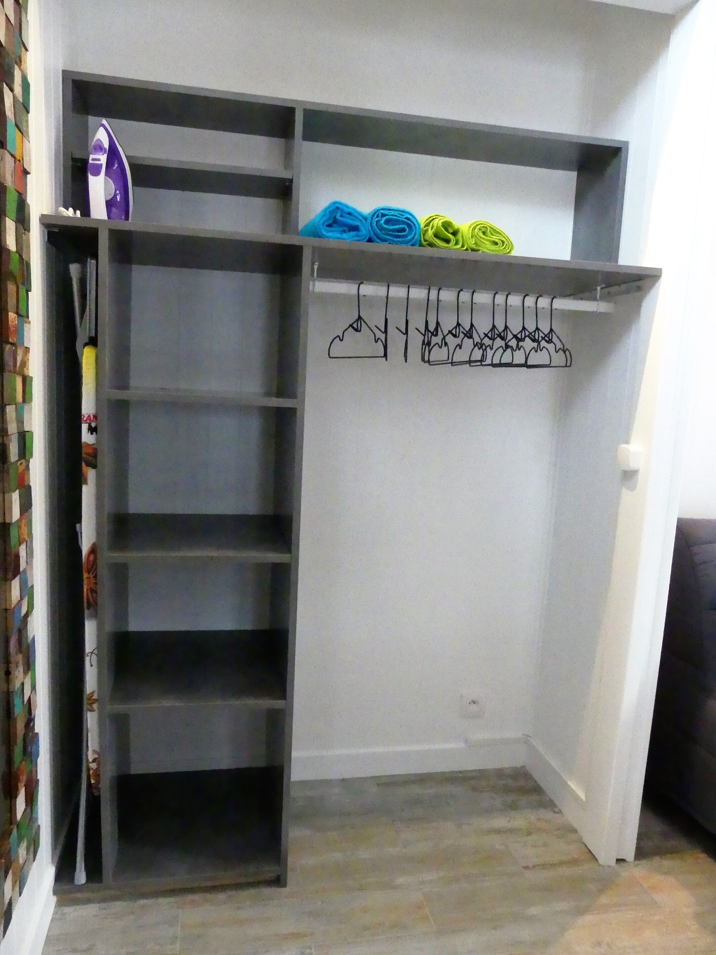 A walk-in closet with open shelves and a hanging rod.