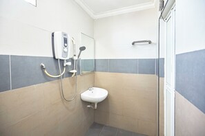 A bathroom with a sink, a handheld showerhead, and a wall-mounted faucet. - Hotel Pritty (Kuala Lumpur)