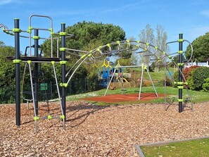 A playground with various climbing structures and a swing set.