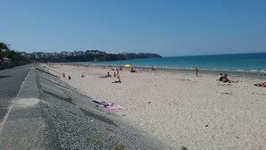 A beach with people sunbathing and walking along the shore. - Beautiful duplex near the sea (the islands) (Donville-les-Bains)