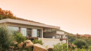 Une maison moderne avec un toit plat, de grandes fenêtres et un balcon.