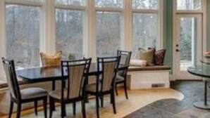 A spacious kitchen with a large island, ample natural light from large windows, and a view of the outdoors.