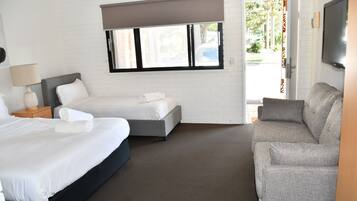 Een hotelkamer met een bed, een bank, een raam en een televisie.