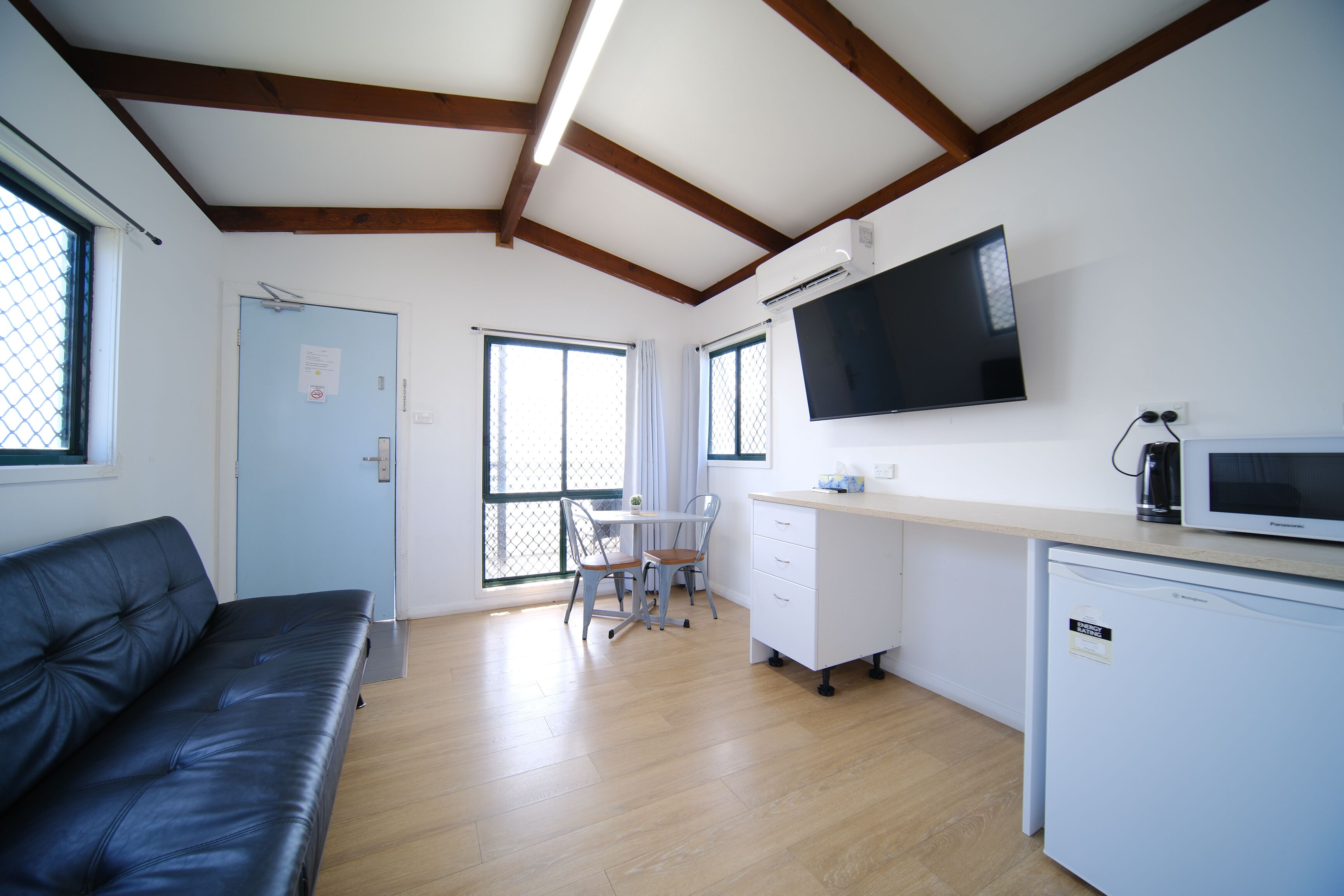 A compact living space with a kitchenette, a dining area, and a seating area.