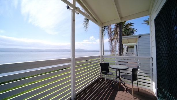 A balcony with a view of the sea, white railings, and two chairs. - Lakeside Inn Illawarra  (Windang)