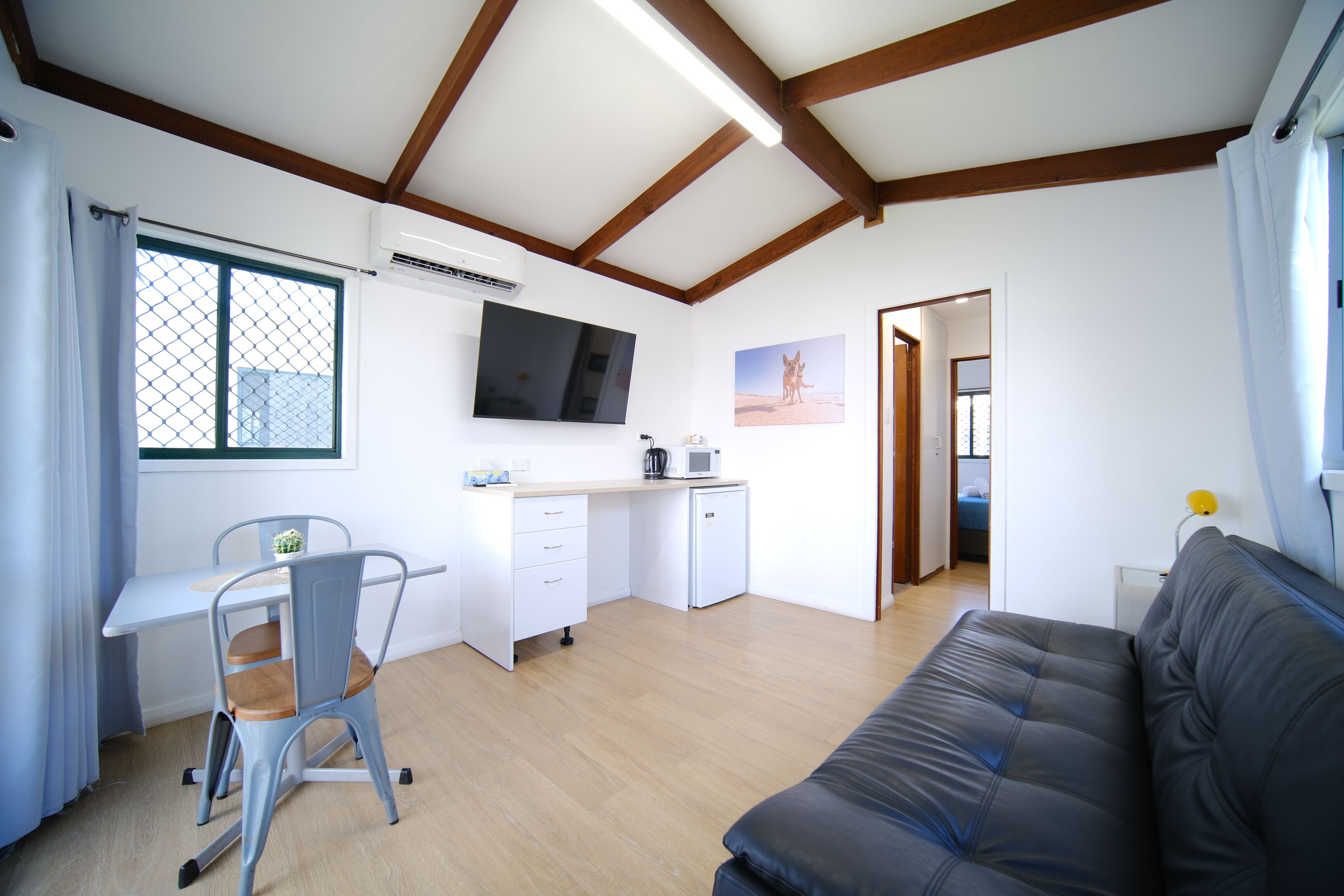 A compact living space with a kitchenette, a dining area, and a sofa.