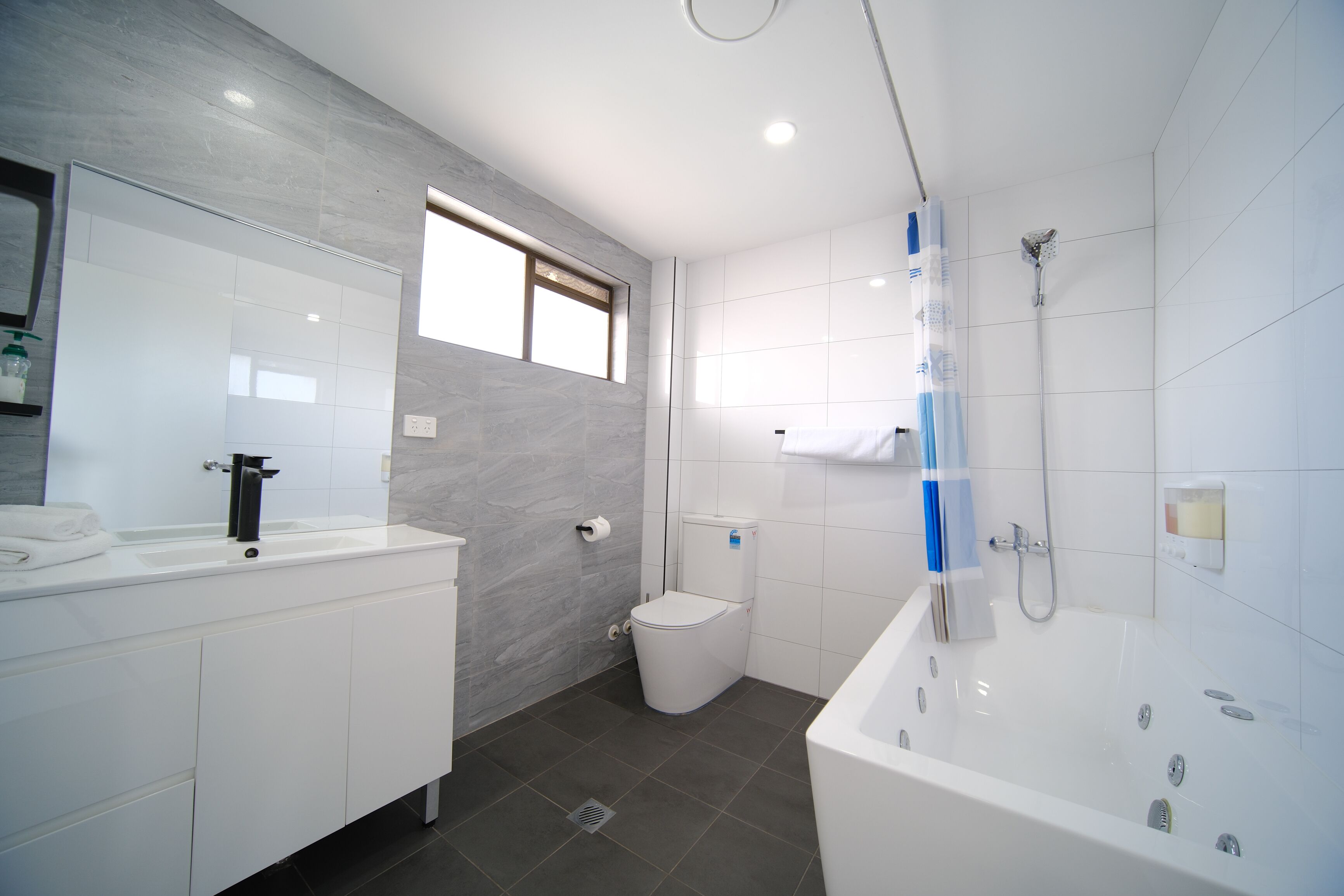 A modern bathroom with a white sink, toilet, and bathtub.