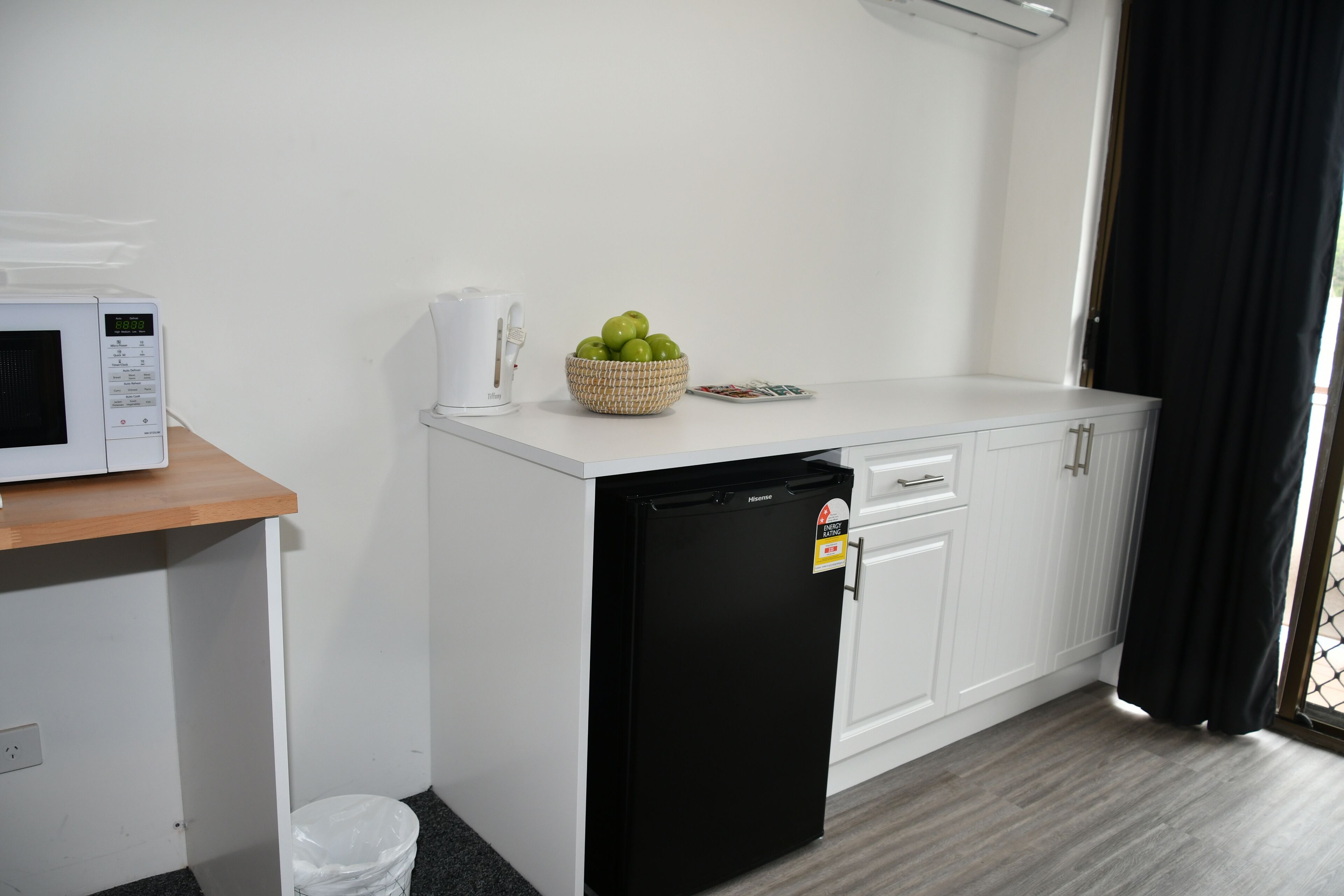 A compact kitchenette with a microwave, coffee maker, and a small refrigerator.