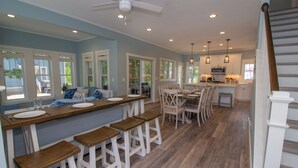 A spacious kitchen with a central island, bar stools, and a dining area with chairs. - Renters paradise in Beachwalk Resort (Michigan City)