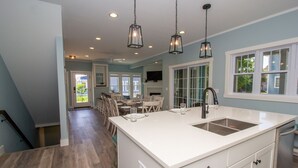 A spacious kitchen with a large island, white cabinetry, and pendant lighting. - Renters paradise in Beachwalk Resort (Michigan City)