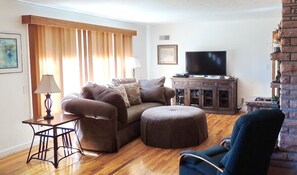 Cozy living room with a leather sofa, armchair, and flat-screen TV.