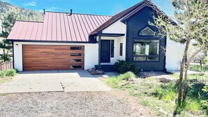 A modern two-story house with a garage, a large window on the second floor, and a sloped roof. - One of the nicest house rentals available in Lyons, Colorado (Lyons)
