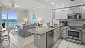A modern kitchen with granite countertops, stainless steel appliances, and a view to the ocean. - Beach Retreat 407  Gulf Front, Dog friendly, Beach Service (Miramar Beach)