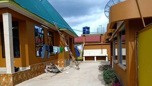 Ein Innenhof mit Betonboden, ein Gebäude mit Gründach und einem Wassertank auf dem Dach.