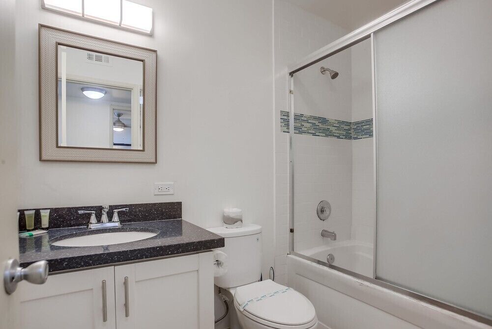 Een badkamer met een wastafel, toilet en een douchecabine.