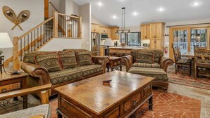 A spacious living area with a wooden staircase, leather sofas, a coffee table, and a dining table with chairs. - Walk to Summit, Spa, BBQ, Fireplace (Big Bear)