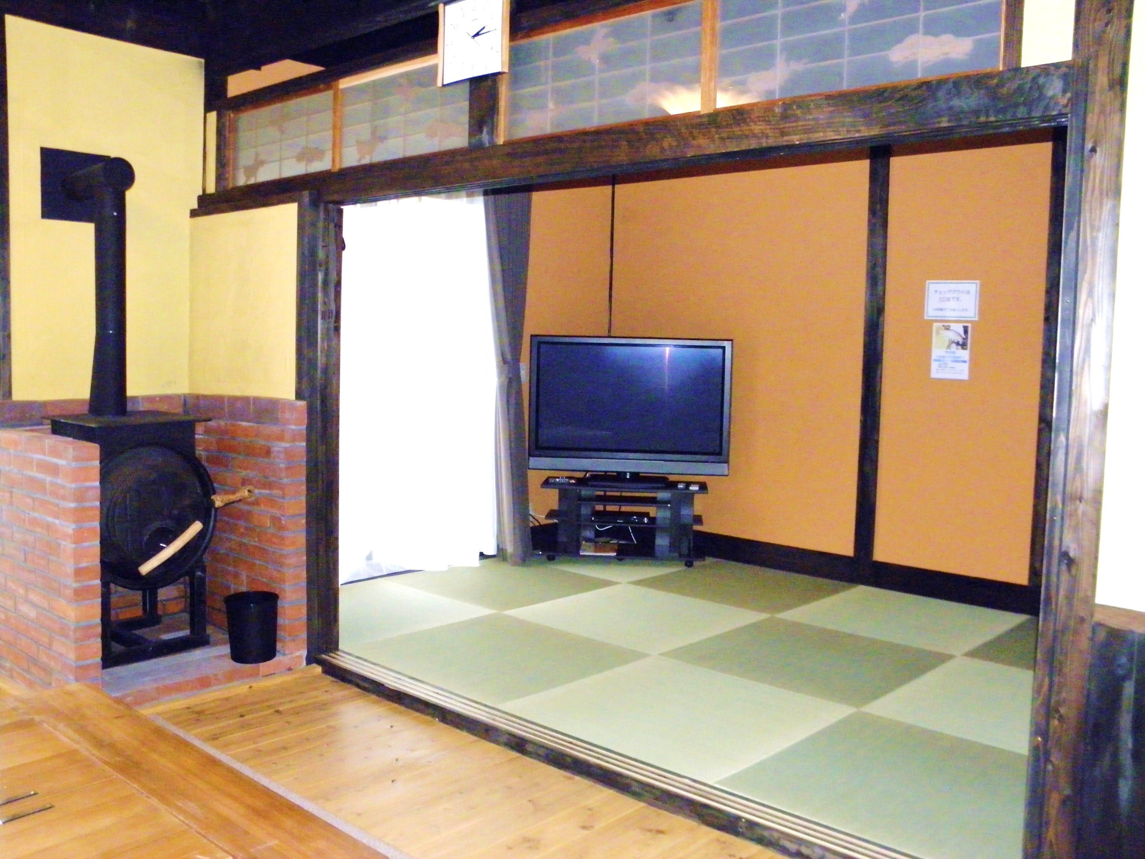 Een traditionele Japanse kamer met tatami vloeren, een televisie en een open haard.