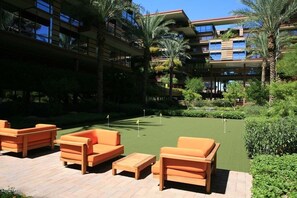 Relax and unwind on the putting green, surrounded by lush greenery and comfortable lounge chairs.