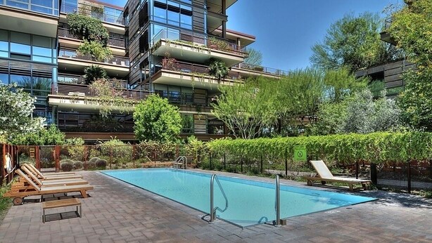 A modern apartment building with a rooftop garden, a swimming pool, and outdoor seating. - Old Town Scottsdale - Optima Camelview - Modern/Furnished, Walk To All Amenities (Scottsdale)