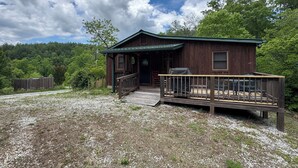 Une cabane en bois avec un porche, une terrasse couverte et une allée gravillonnée.