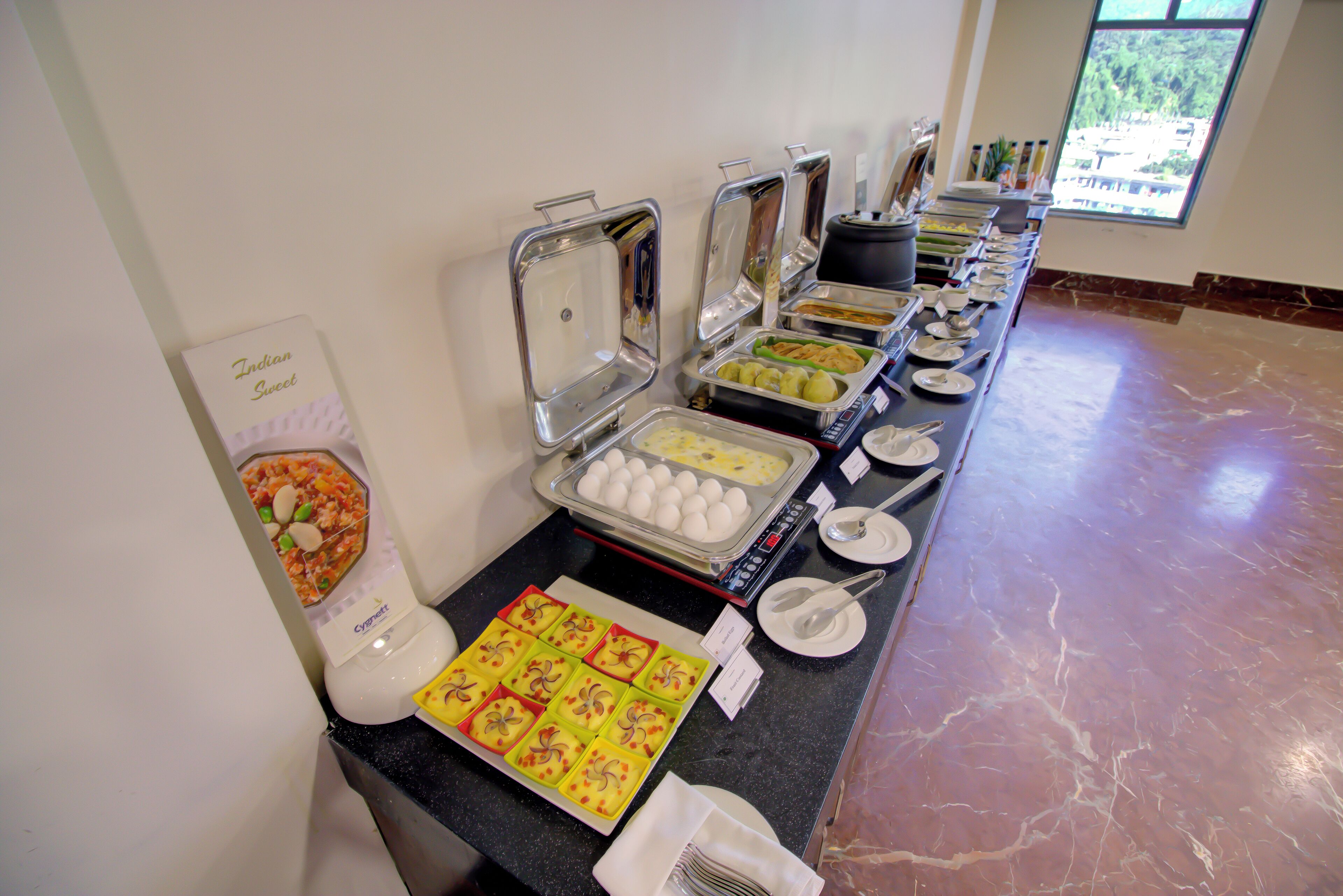 Een buffet met diverse gerechten en bestek.