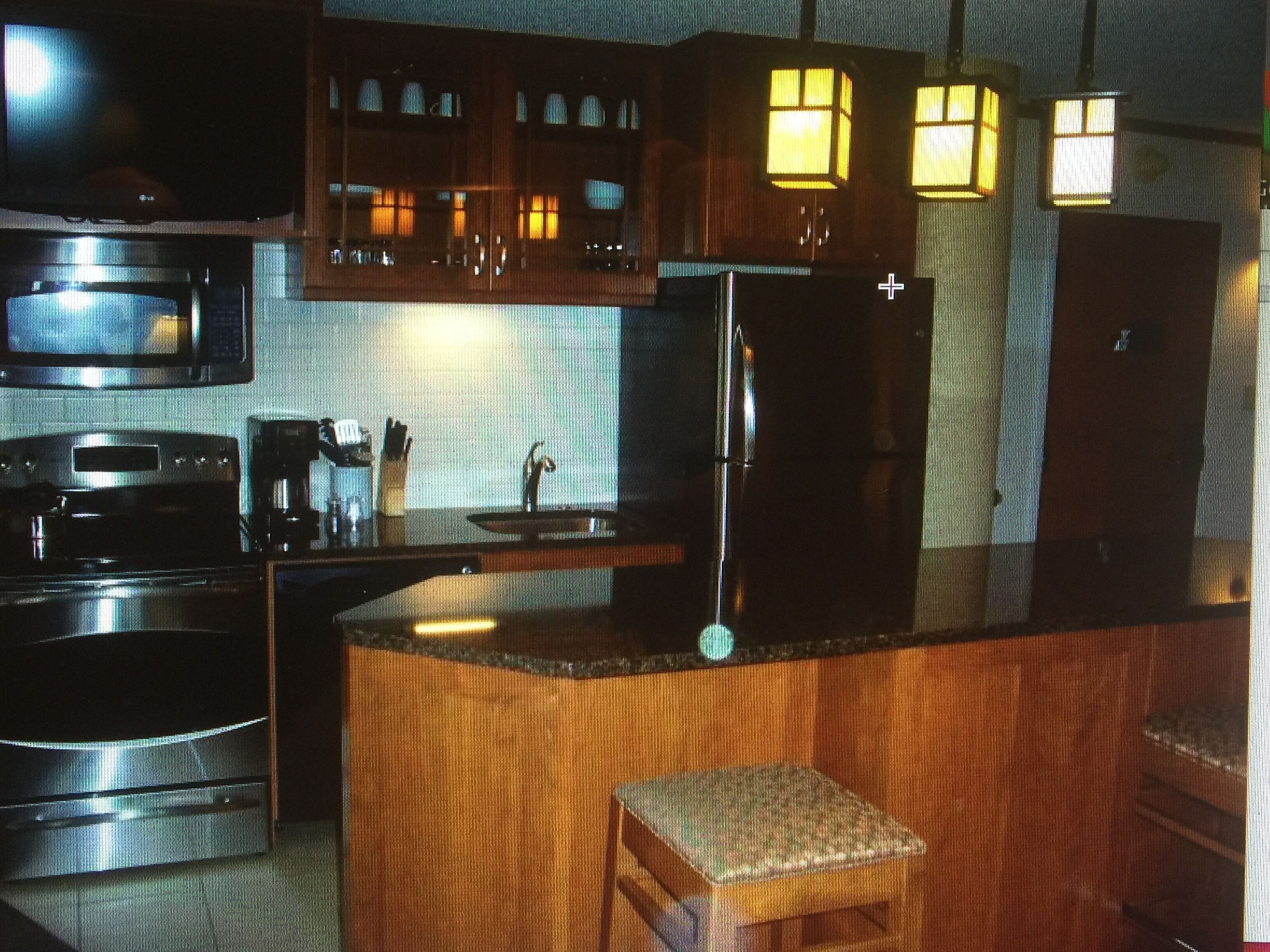 A kitchen with wooden cabinets, a refrigerator, a microwave, and a coffee maker.