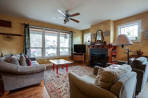 A living room with a fireplace, two sofas, a coffee table, and a television.