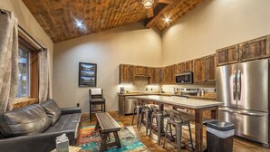 A modern kitchen with wooden cabinets, stainless steel appliances, and a bar area.
