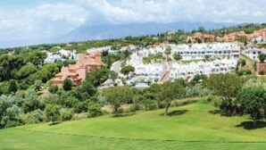 Ein Golfplatz mit Blick auf ein Wohngebiet im Hintergrund.