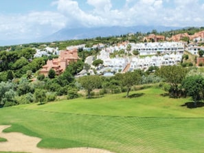 Un parcours de golf offrant une vue sur un quartier résidentiel en arrière-plan.