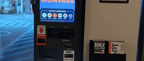 A WowPass payment machine with a screen displaying options for exchange, payment, and TMoney.
