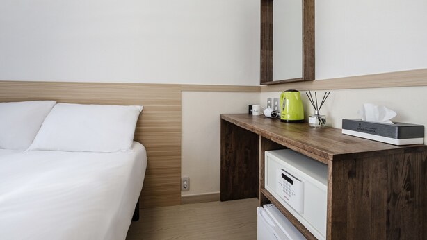 A hotel room with a bed, a wooden desk with a mirror, a coffee maker, and a tissue box. - Five Hotel Jongno (Seoul)