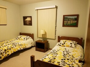 Two single beds with wooden headboards and floral-patterned bedspreads.