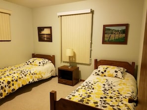 Two single beds with wooden headboards and floral-patterned bedspreads.