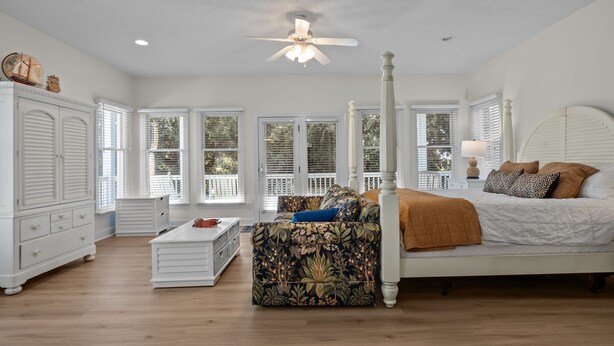 A spacious bedroom with a four-poster bed, a ceiling fan, and large windows. - Large, Pet Friendly, Private Pool, Golf Cart,Easy Beach Access (Emerald Isle)