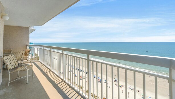 Ein Balkon mit Blick auf Strand und Meer.