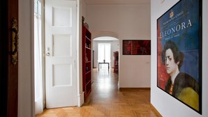 A hallway with wooden flooring, white walls, and a red bookshelf. - Elegant And Spacious Apartment In The Very Historical Centre Of Naples (Napoli)