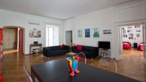 A spacious living room with two black sofas, a wooden coffee table, and a clear glass table. - Elegant And Spacious Apartment In The Very Historical Centre Of Naples (Napoli)