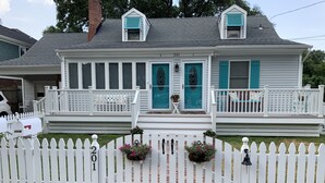 A two-story house with a white picket fence, numbered 201. - North End Beach Cottage Apartment - One block from beach (Virginia Beach)