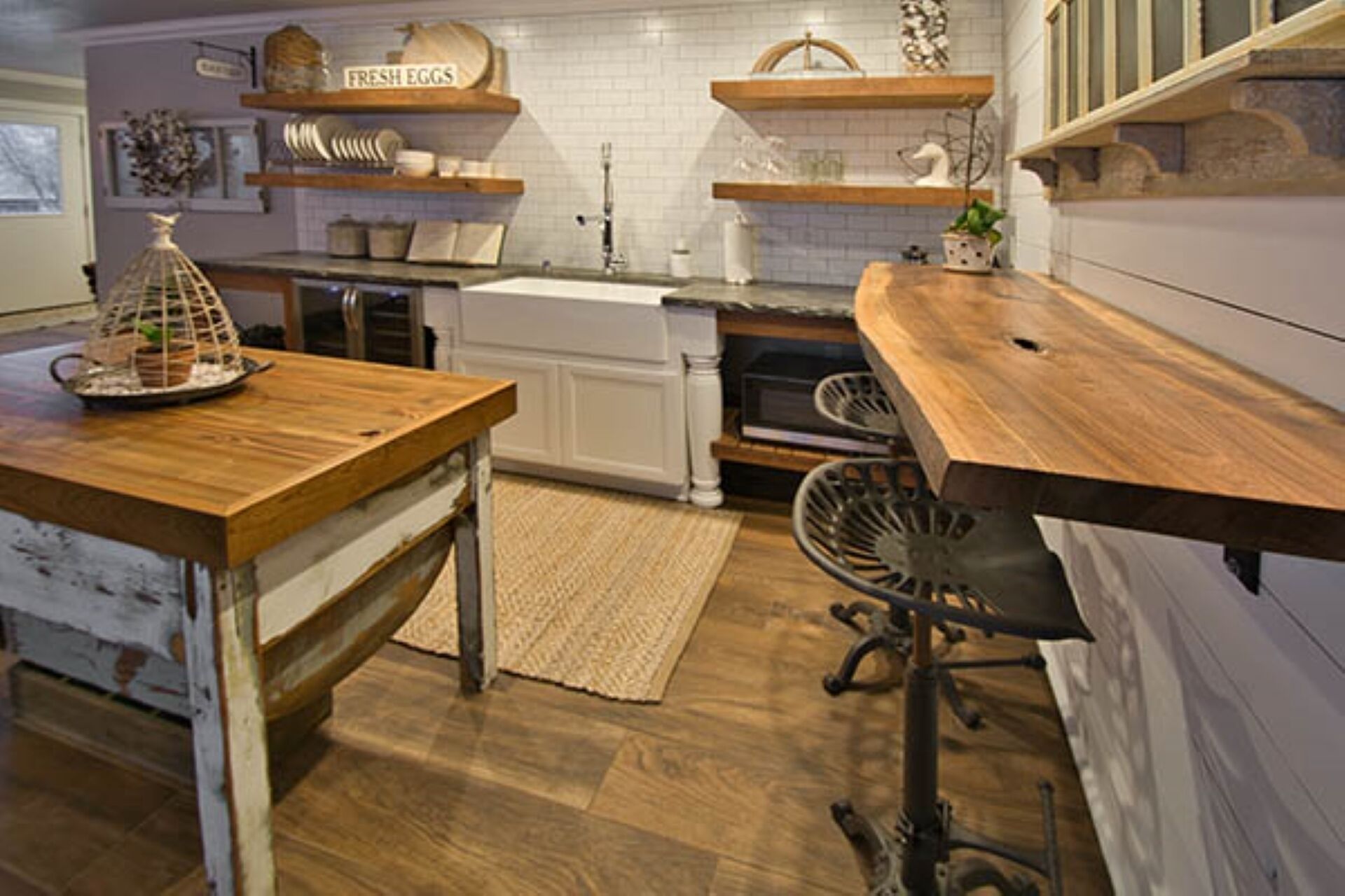 A kitchen with wooden countertops, white cabinets, and a hanging pot rack.