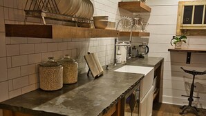 Une cuisine dotée d’un plan de travail en granit, de meubles en bois et d’un porte-ustensiles suspendu.