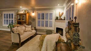 Un salon chaleureux avec une cheminée, un canapé, une table basse et une lampe décorative.