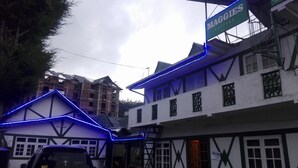 A building with a sign reading "Maggies Cottage" and another sign indicating "Rooms Available." - Maggies Cottage NuwaraEliya (Nuwara Eliya)